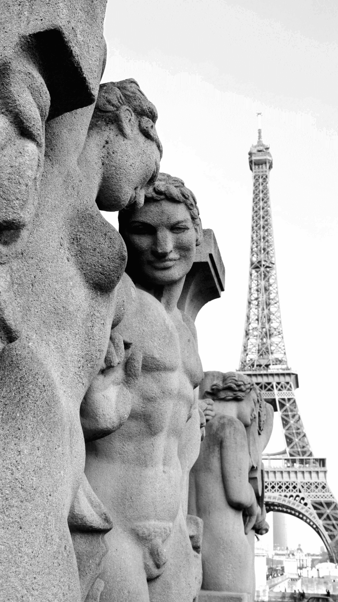 Black and white photo of the sculpture(fountain) in front of the Eiffel tower.